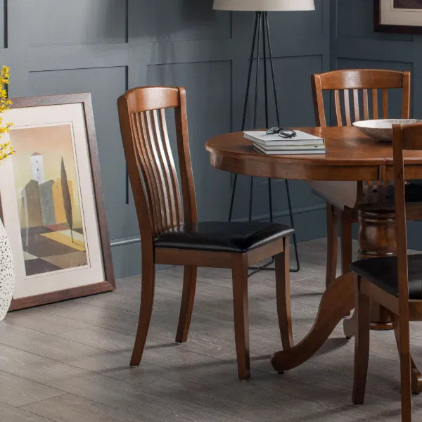 Dining room with wooden table and chairs against a gray wall.