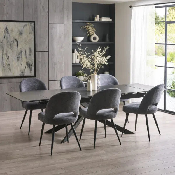 Dining room with a dark gray table and chairs in a modern interior setting.