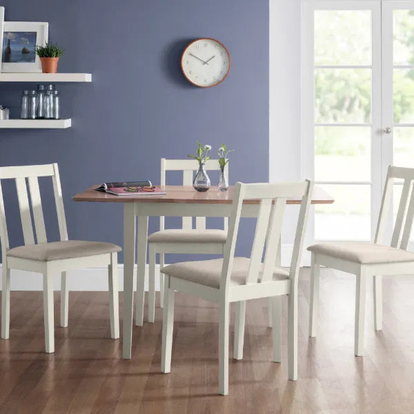 Dining room with a wooden table and white chairs against a blue wall.