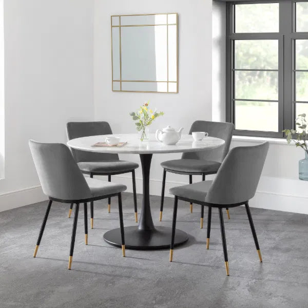 Dining room with a round table and gray chairs in a modern interior setting.