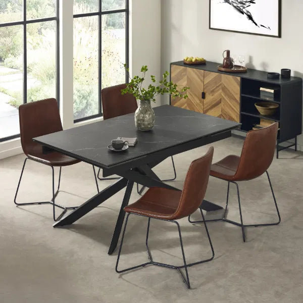 Dining room with a black dining table and brown chairs in a modern interior setting.