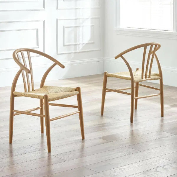 Two wooden chairs with woven seats on a light wooden floor.