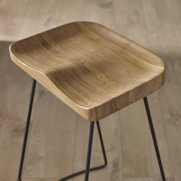Wooden stool with black metal legs on a neutral background