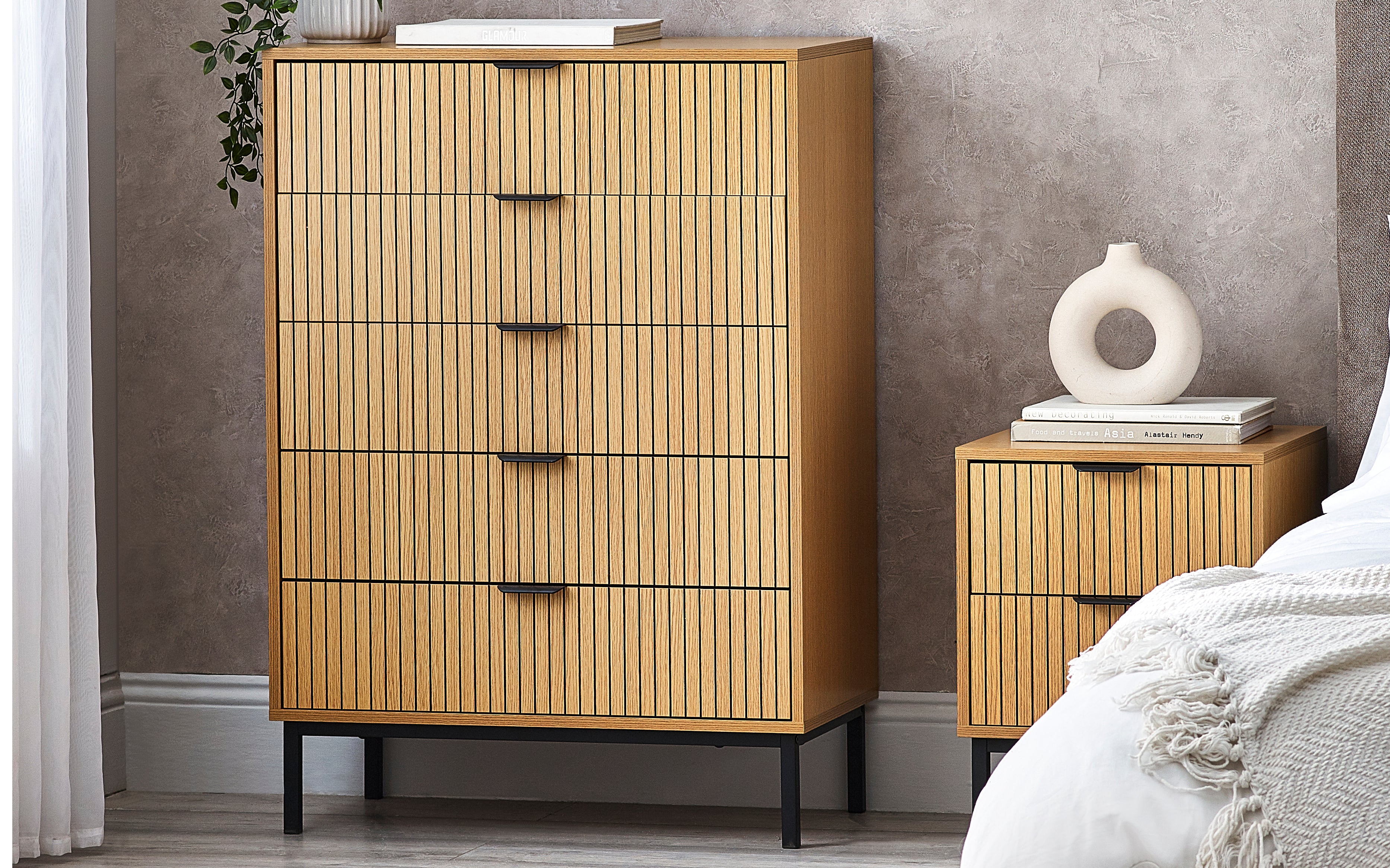 Wooden dresser and nightstand with decorative items in a bedroom setting