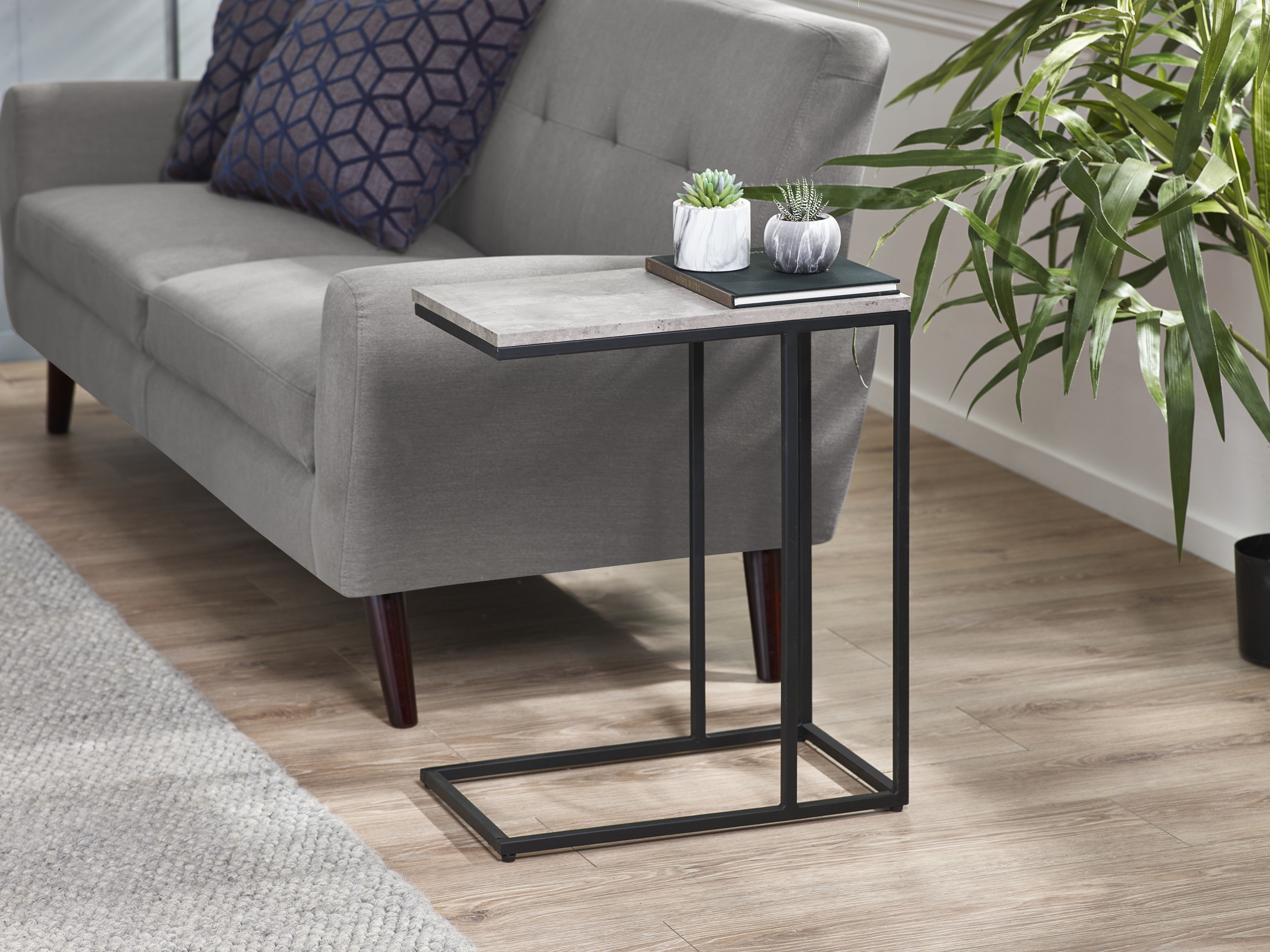 Gray sofa with a small black metal table in a living room setting