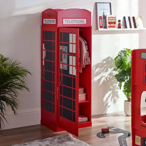 Red telephone booth-shaped bookshelf in a room with plants and a window.
