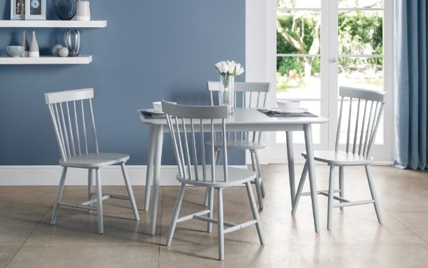 Dining area with a table and chairs in a room with blue walls and a large window.