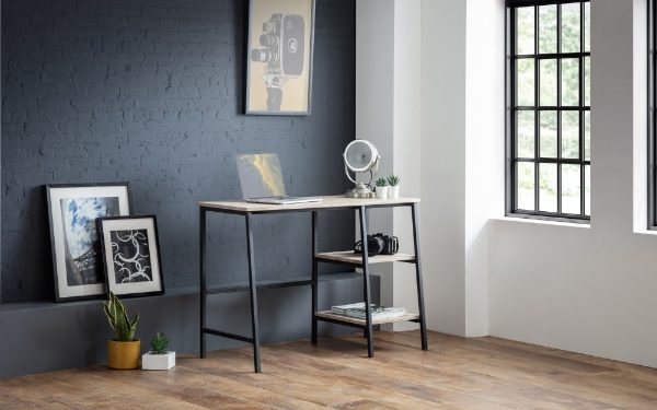 Modern office setup with a desk, laptop, and decor in a room with a window.