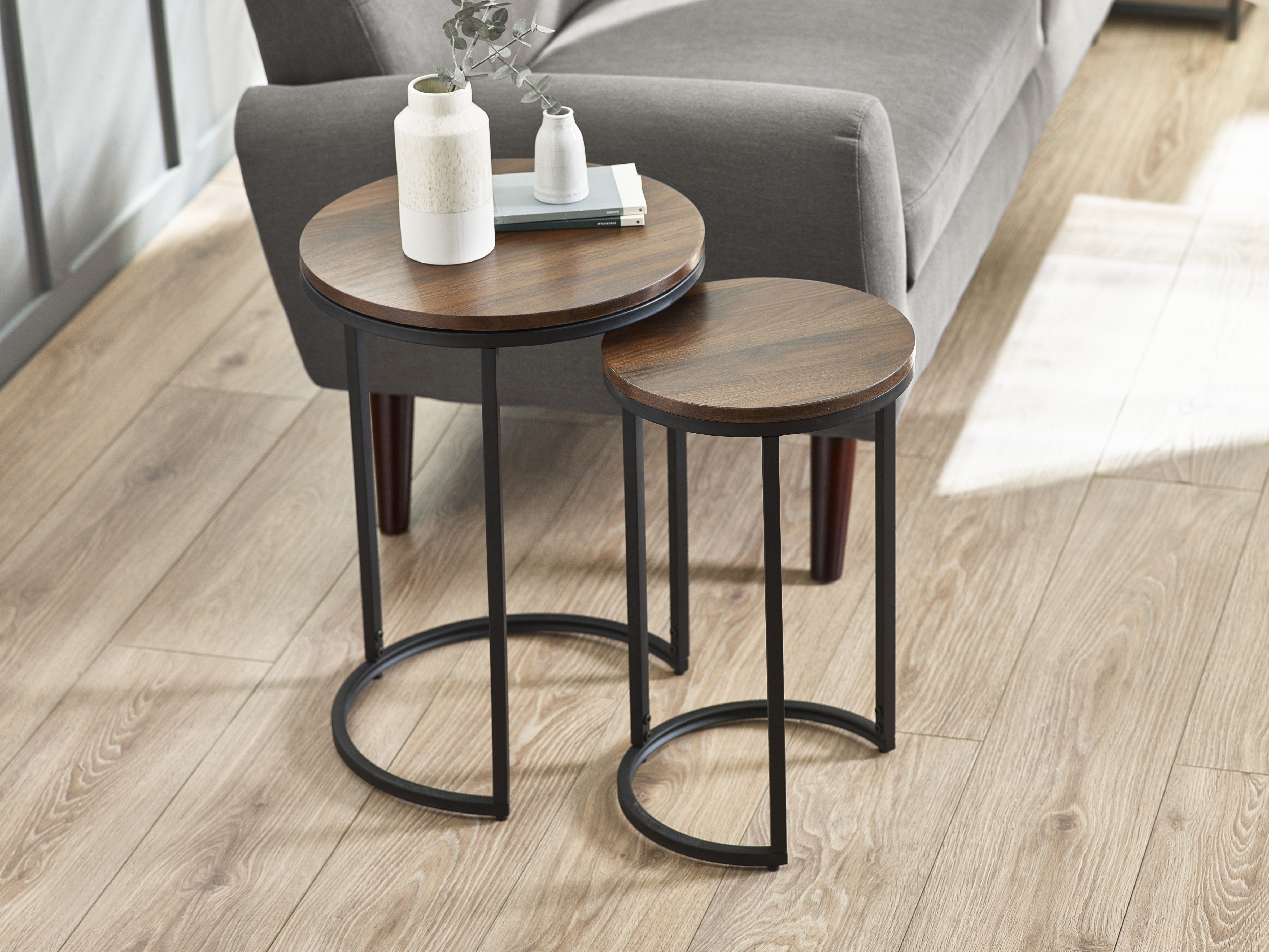 Two wooden side tables with black metal legs in a living room setting.