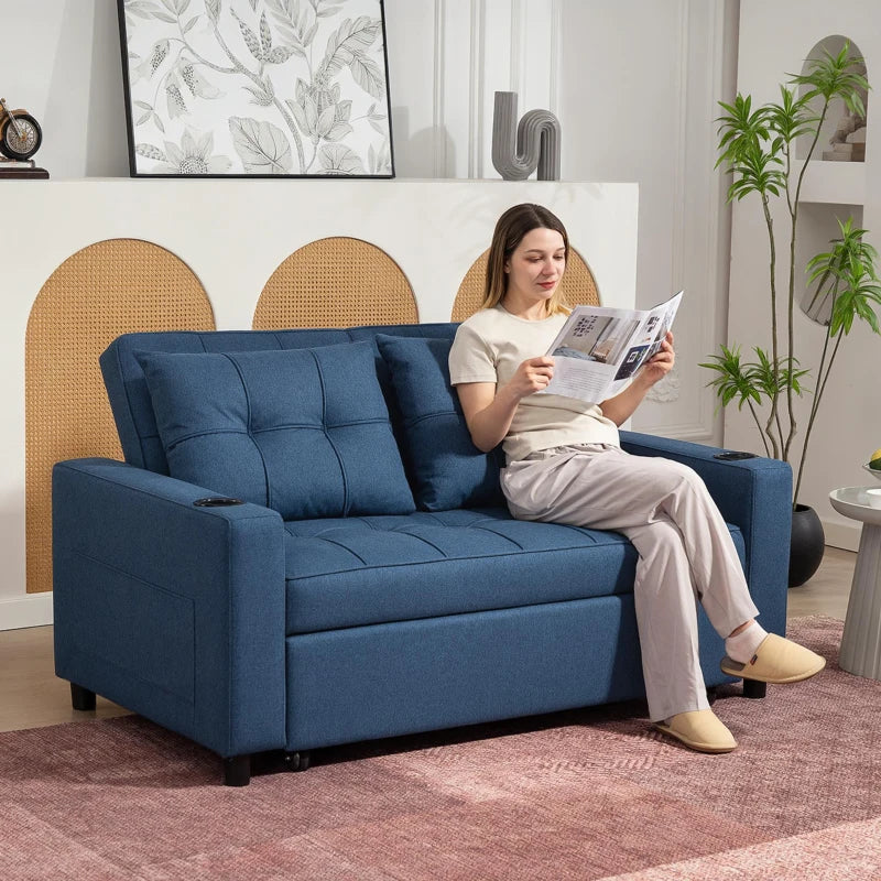 Woman reading a magazine on a blue sofa in a living room.