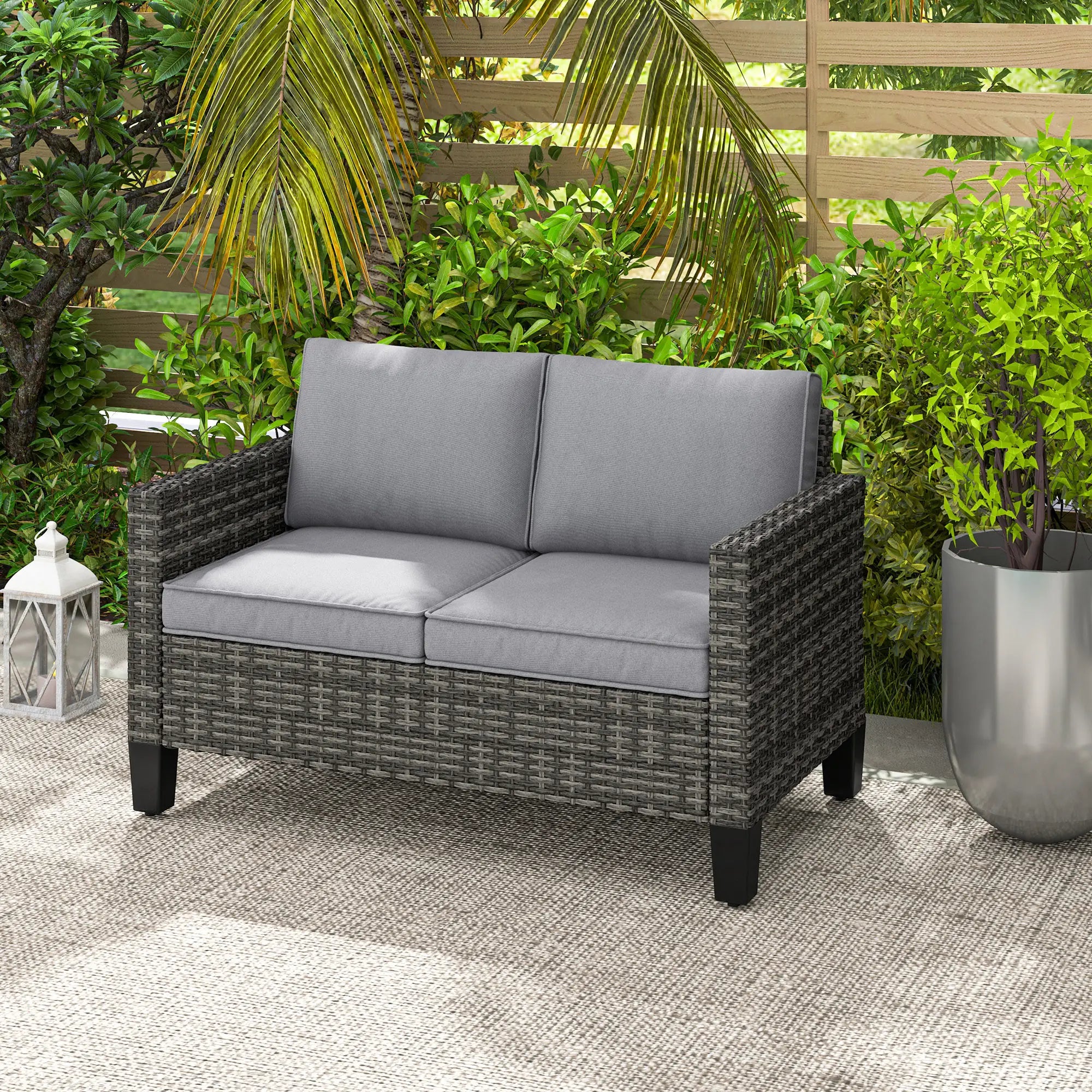 Gray outdoor loveseat with cushions in a garden setting