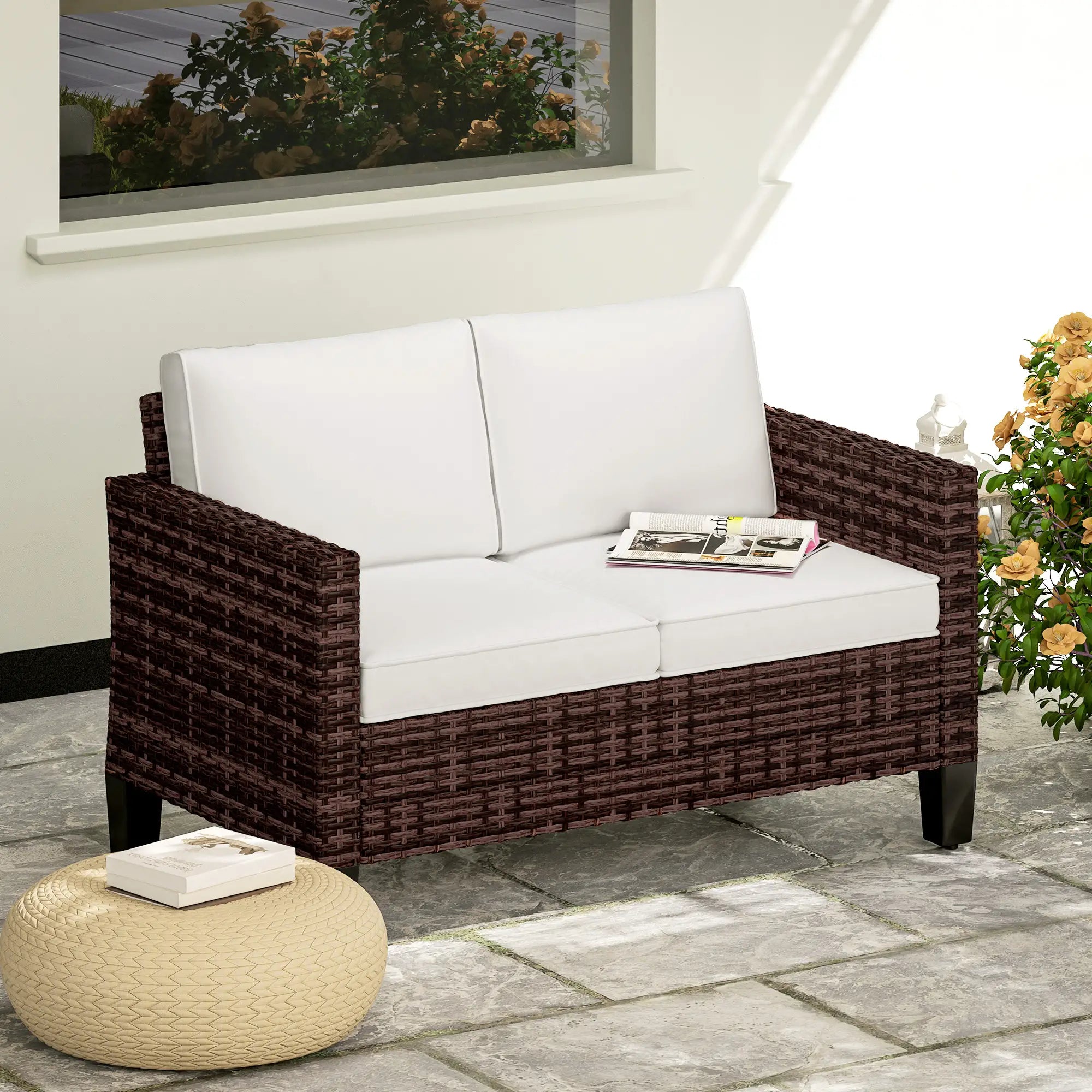 Wicker outdoor sofa with white cushions on a patio