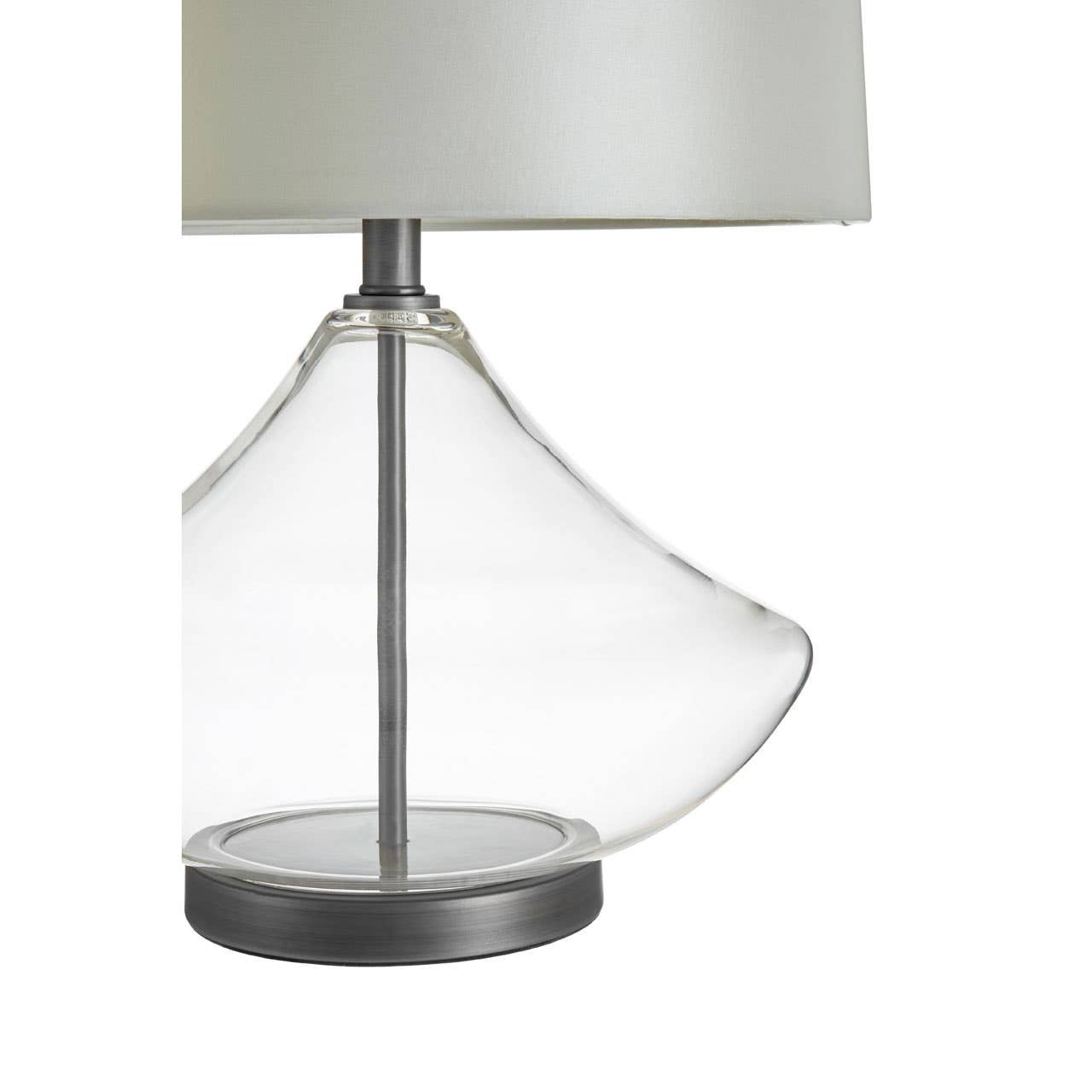 Table lamp with clear glass base and white shade on a white background