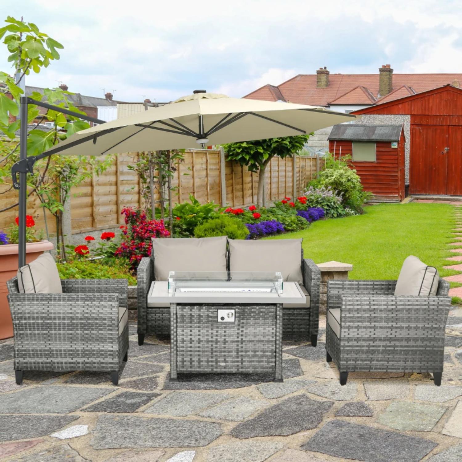 Outdoor patio set with table, chairs, and umbrella on a stone patio with garden and house in the background.