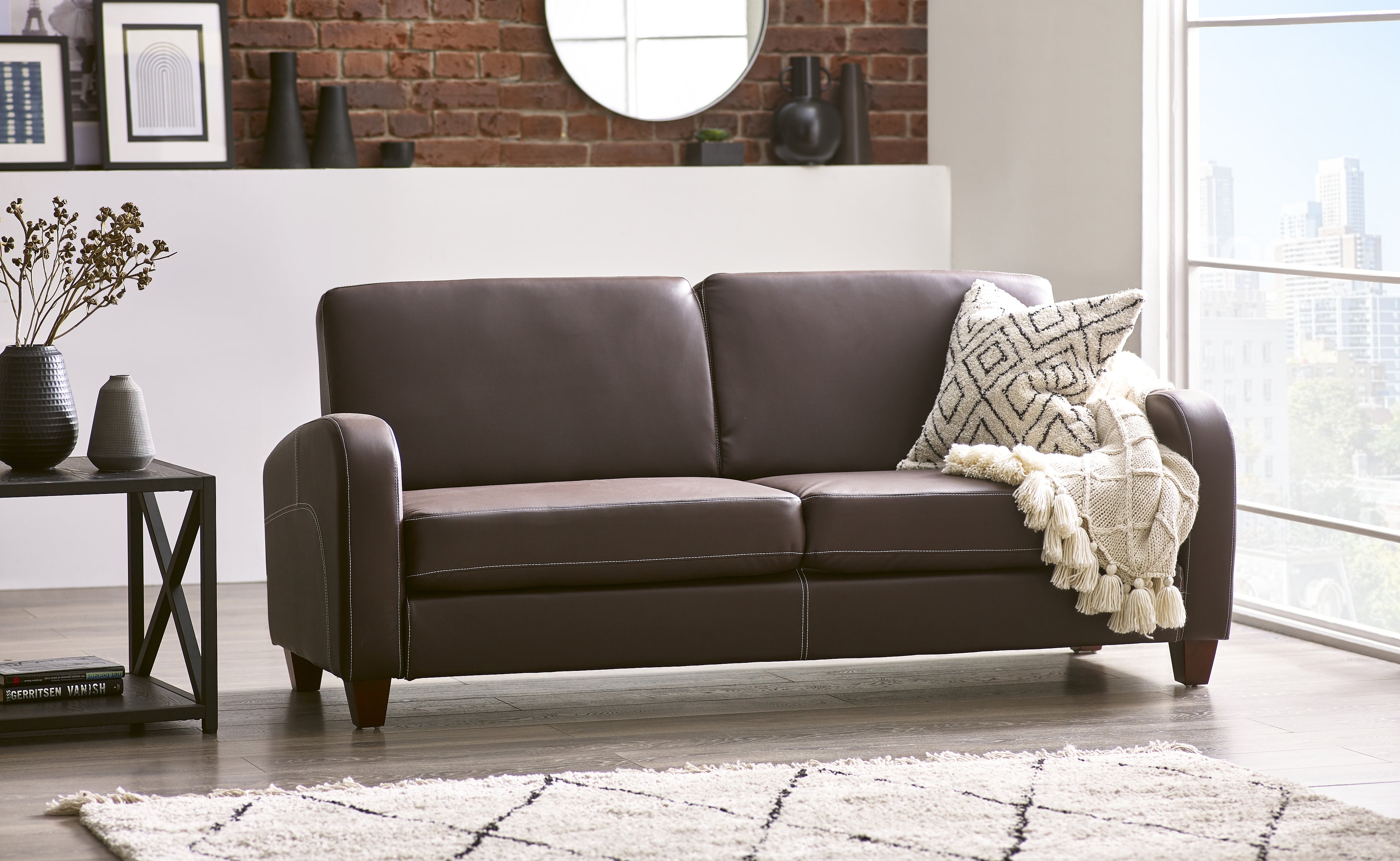 Brown leather sofa in a living room setting with decor elements.