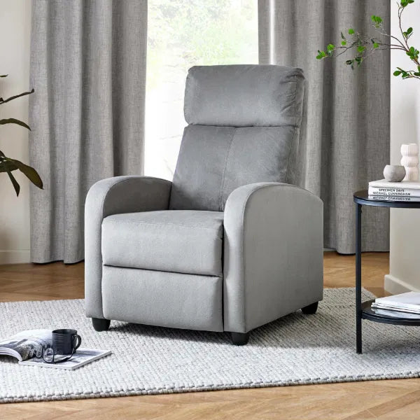 Gray recliner chair in a living room setting with curtains and a side table.