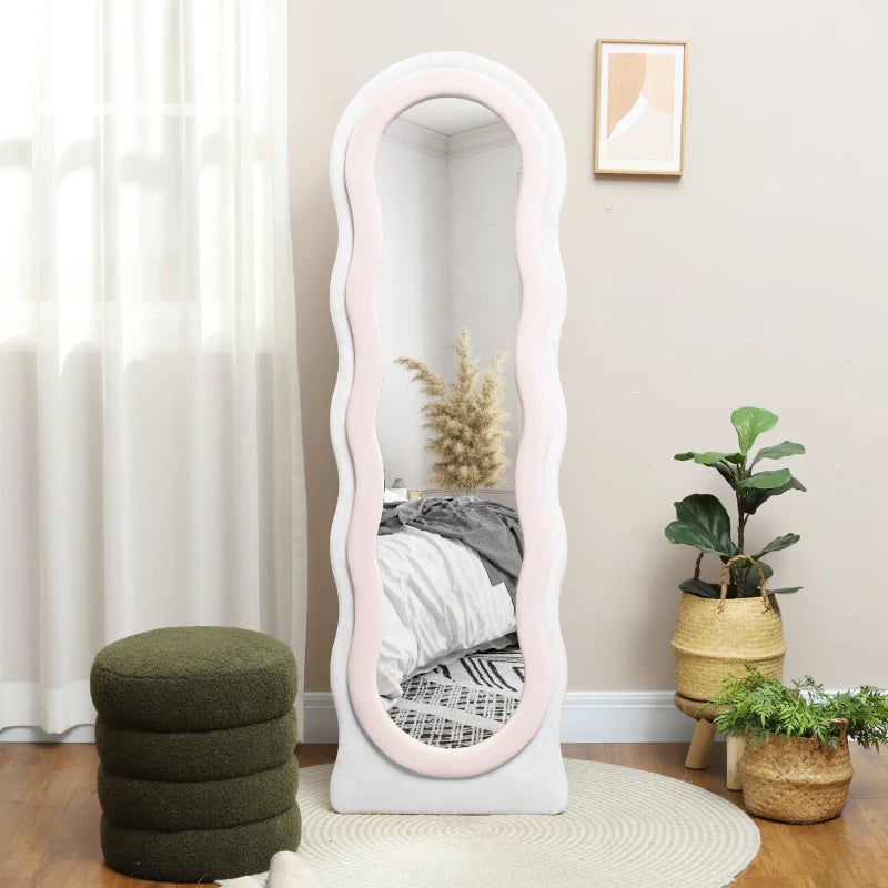 Full-length wavy mirror styled in a bright bedroom with plants and a bed