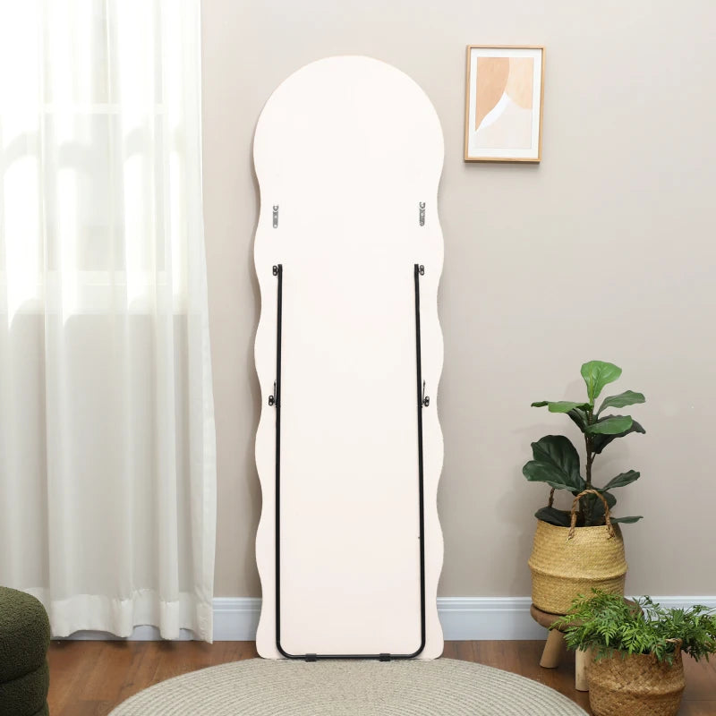 Full-length mirror leaning against a wall in a room with plants and curtains.