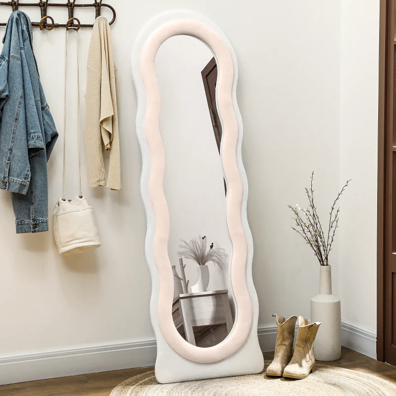 White wavy mirror in a room with clothes and decor items.