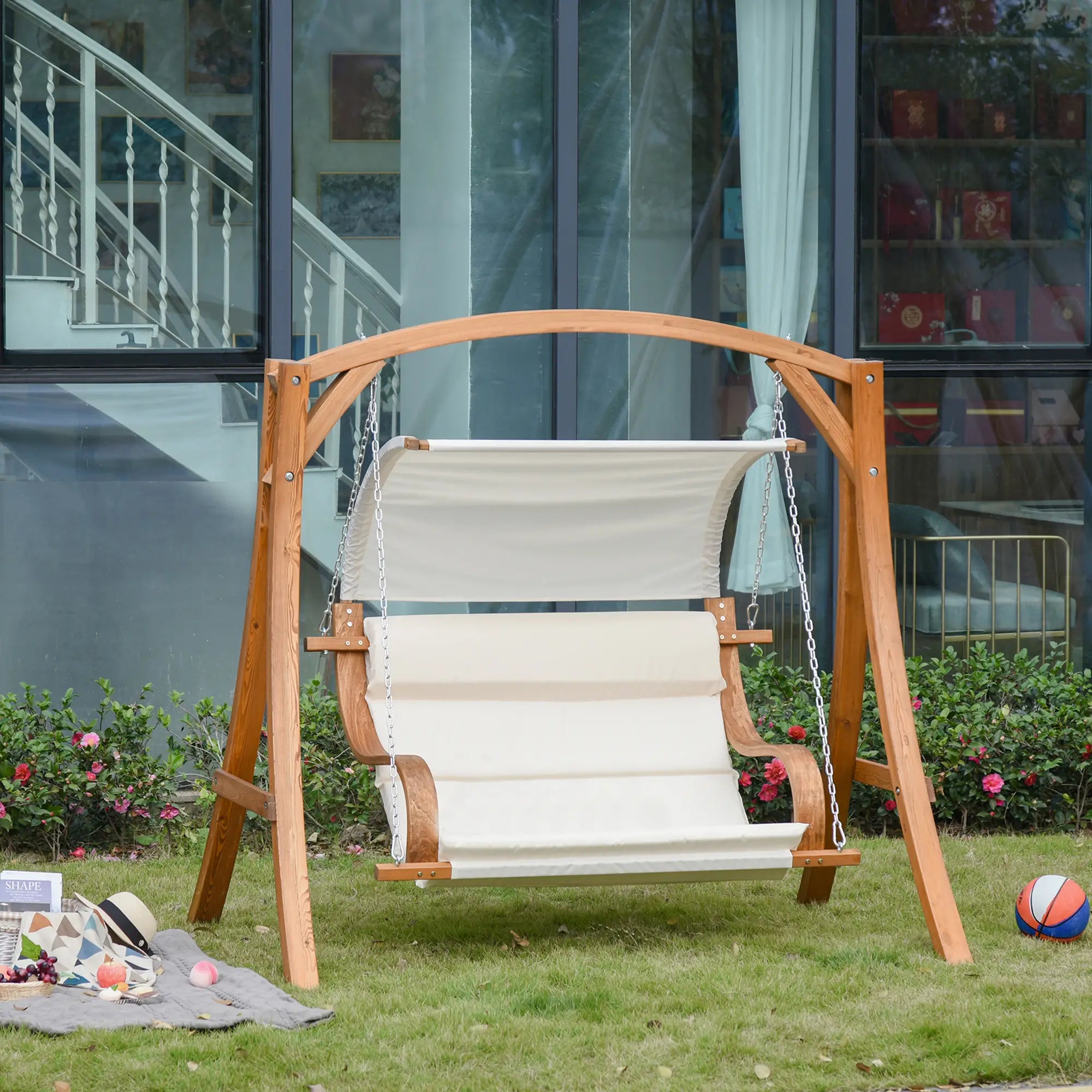 Wooden swing with white cushion in a garden setting