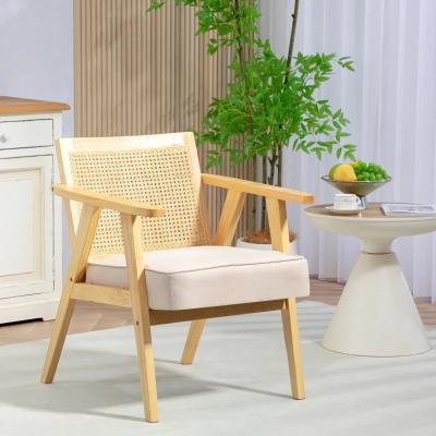 Wooden armchair with woven backrest in a room with a plant and small table.