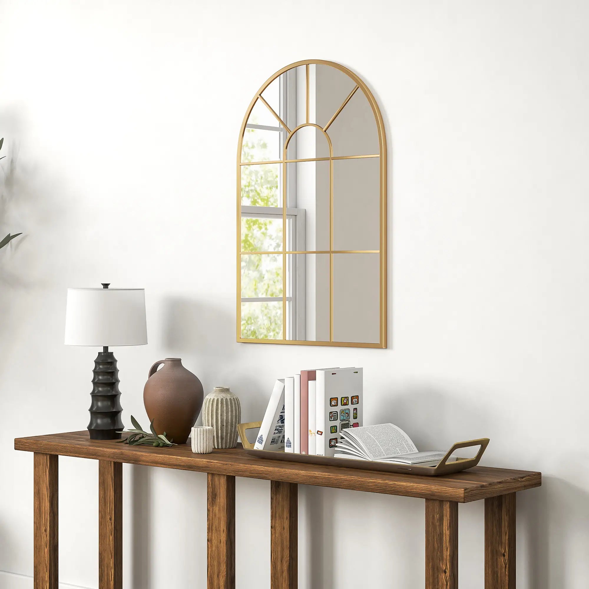 Wooden console table with decorative items against a white wall with a large mirror.