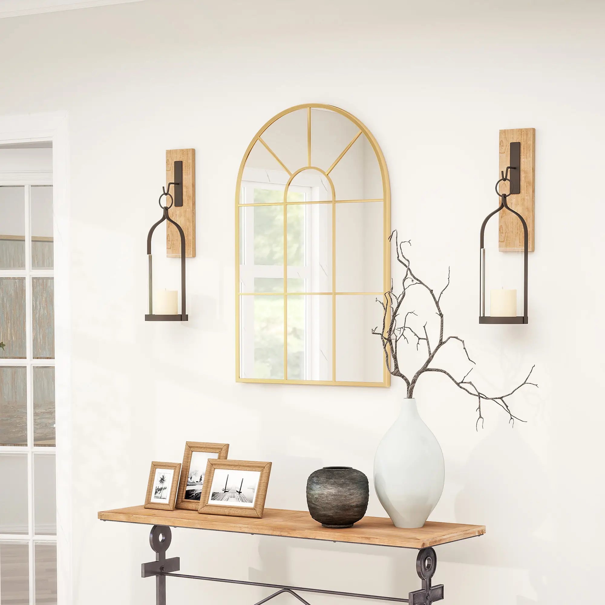 Decorative wall mirror with sconces and a console table in a room.